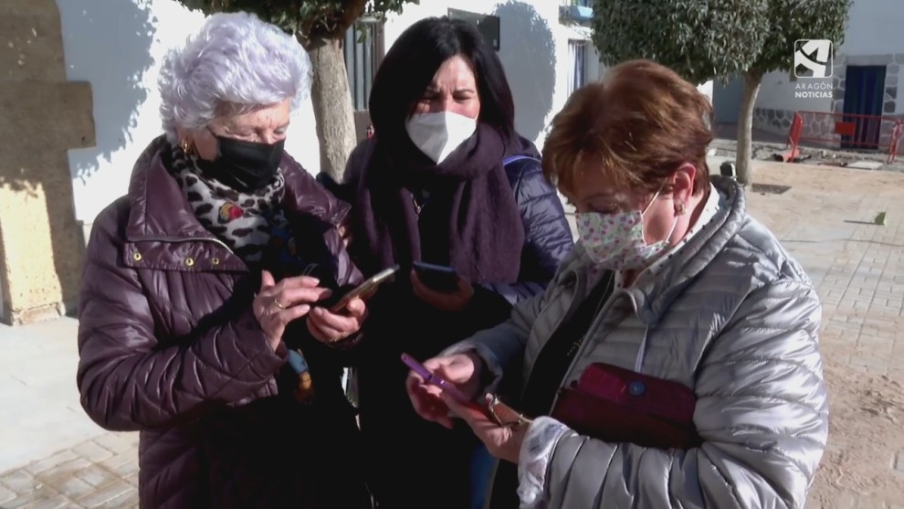 Tres vecinas de Jaulín manejan sus teléfonos móviles. 